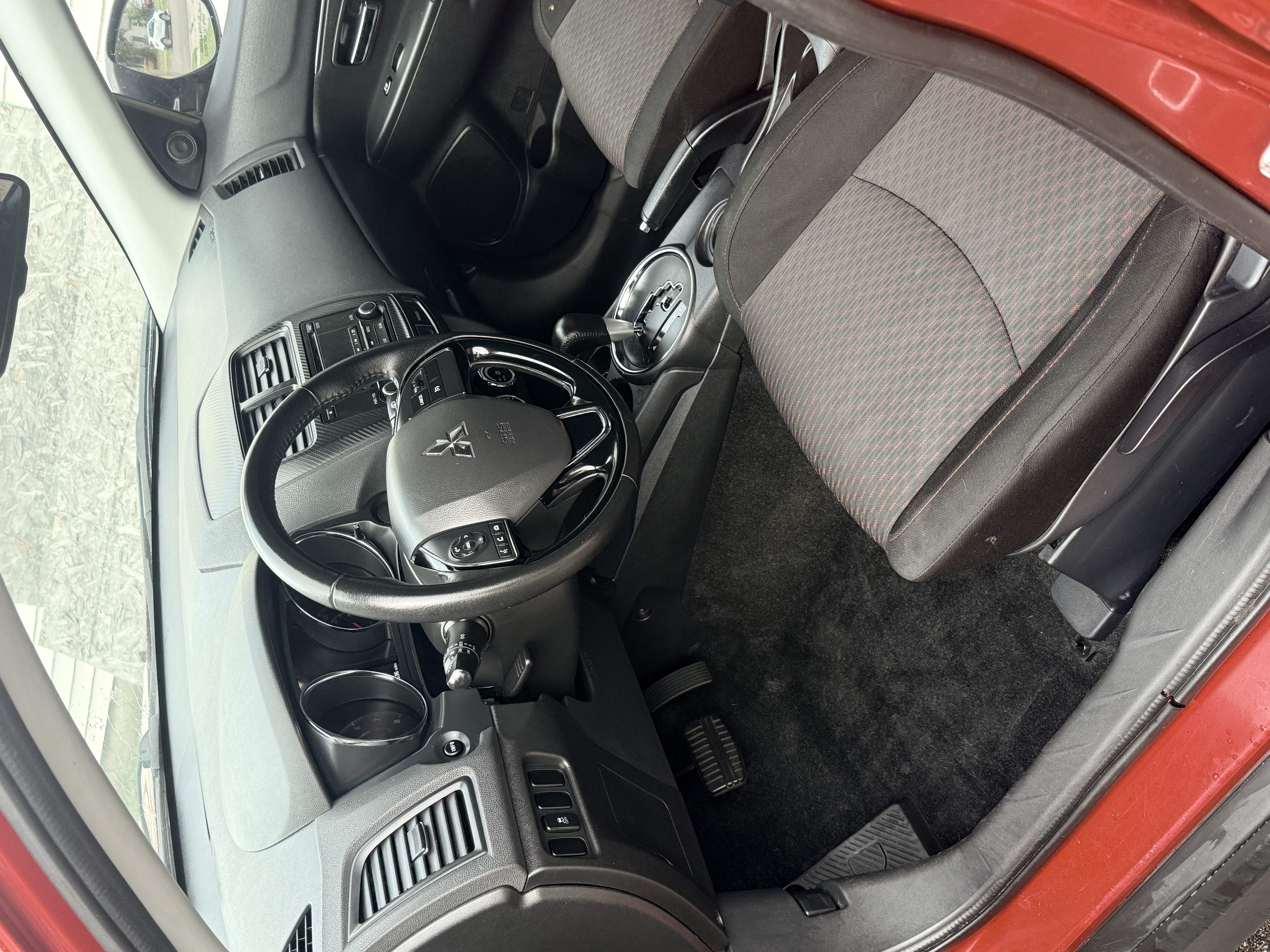 Same Mitsubishi footwell after full detail, seat and floor mat fully clean