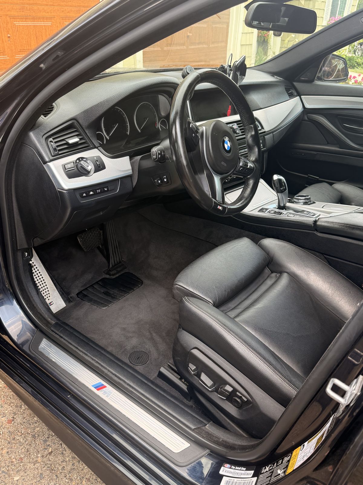 Same BMW driver's seat and carpet after full interior detail, fully clean
