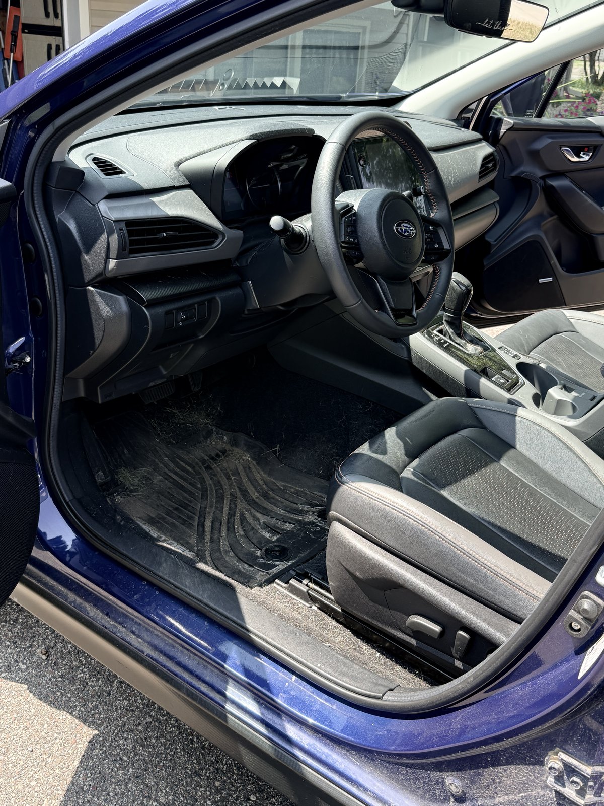 Subaru Crosstrek dashboard and front floor mat before detail, dusty and packed with debris