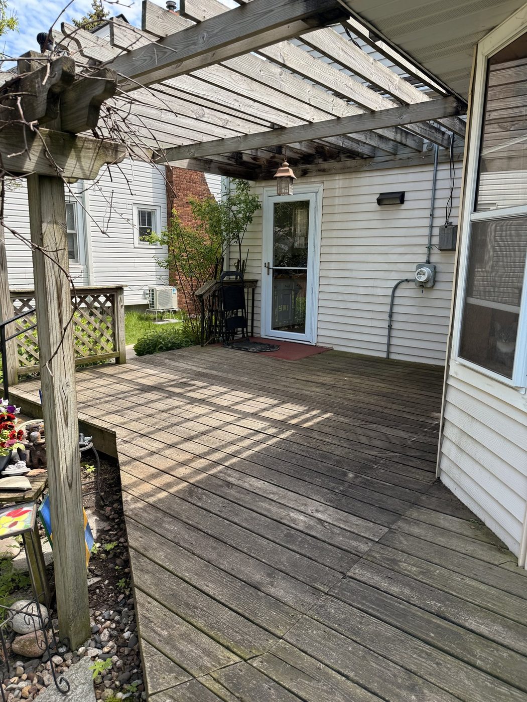 Deck before pressure washing, weathered gray wood, debris on pergola deck