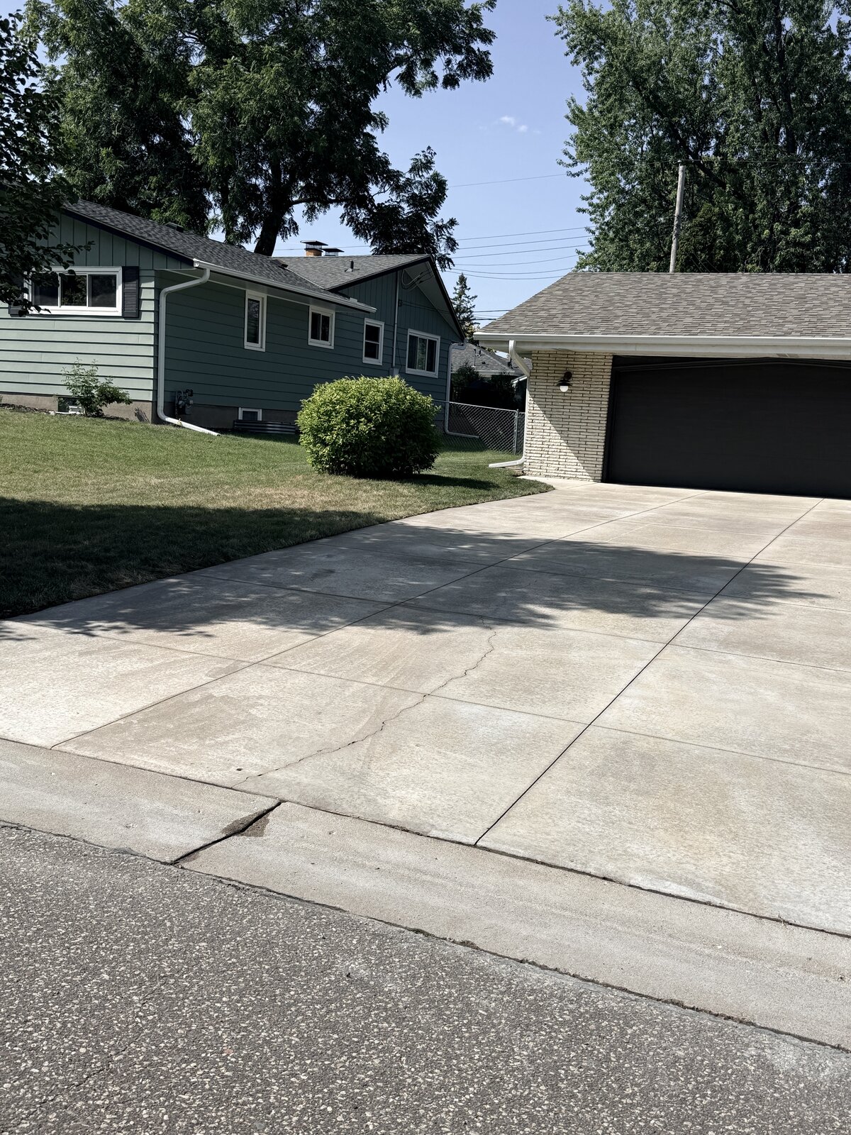 Same commercial driveway with rust staining fully removed, concrete restored